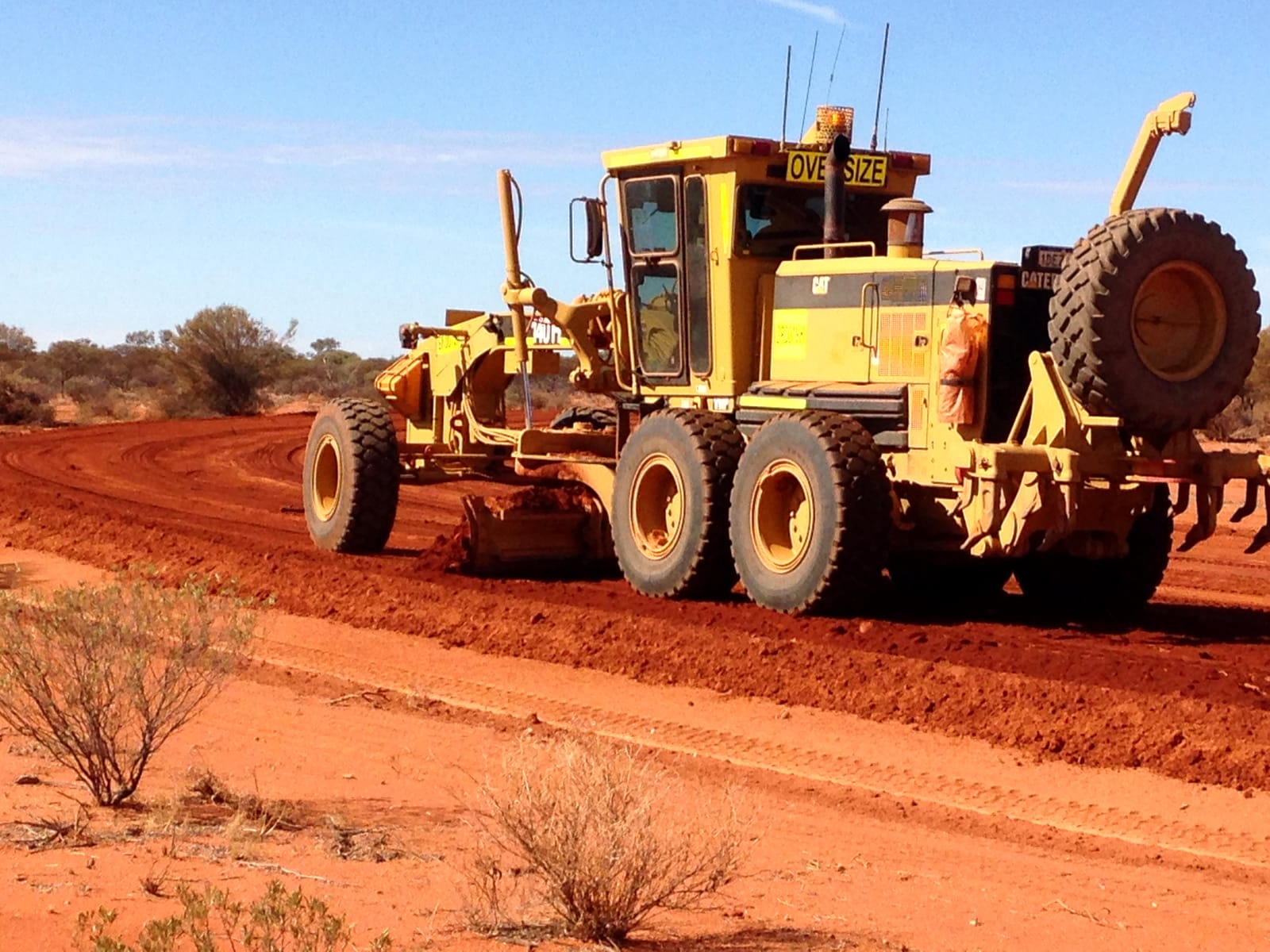 Two graders working in echelon on a red gravel road in the Murchison, cutting a fresh surface
